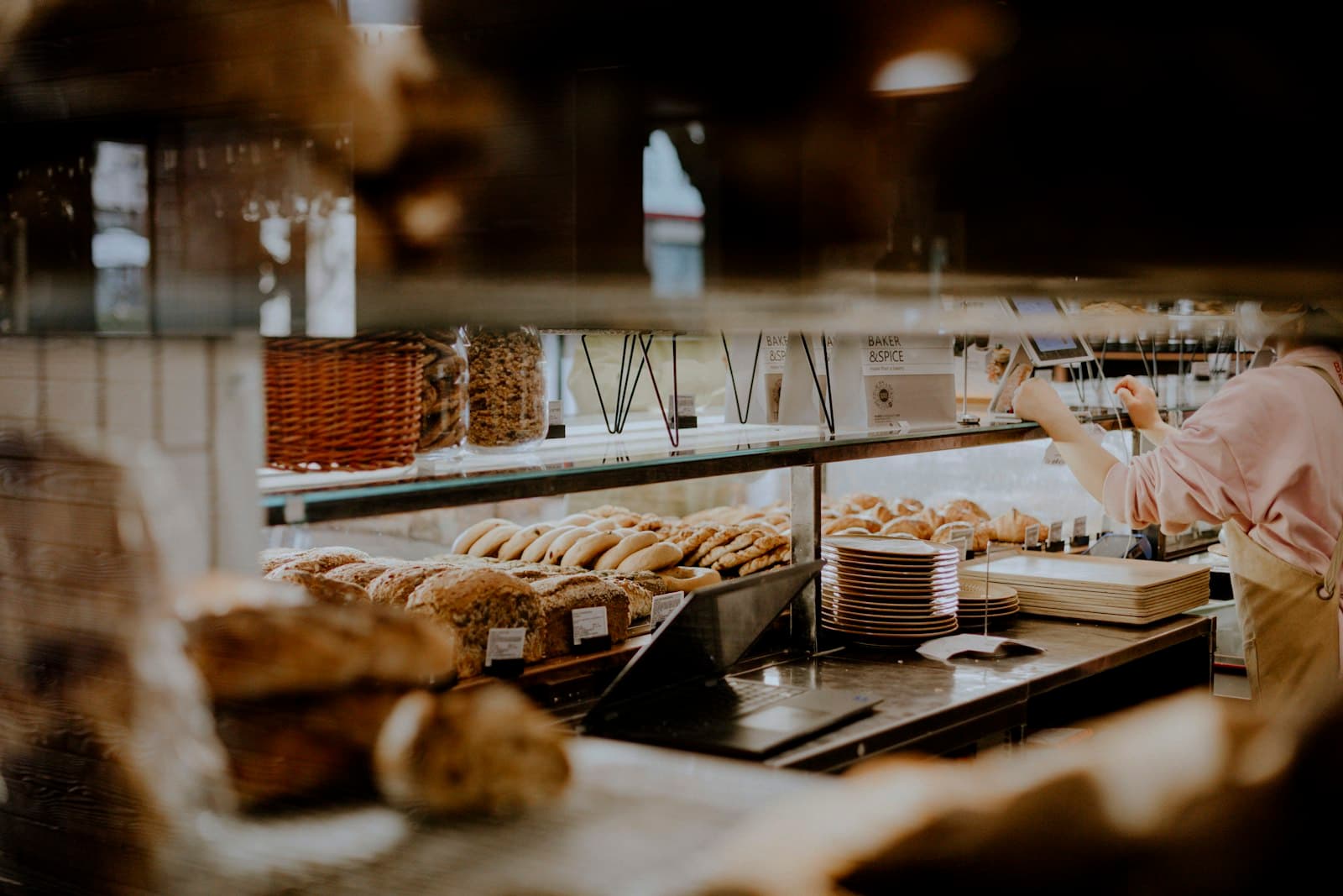 A baker serving behind the counter of a bakery