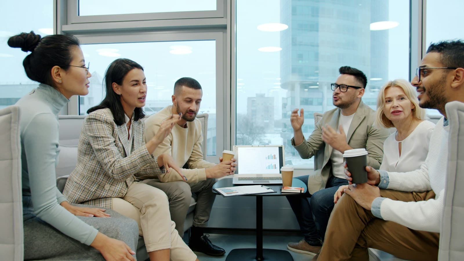 Colleagues chatting over coffee in a bright office