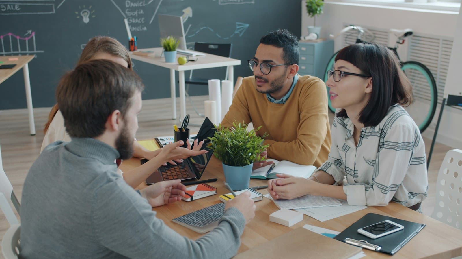 Colleagues talking around a shared office table